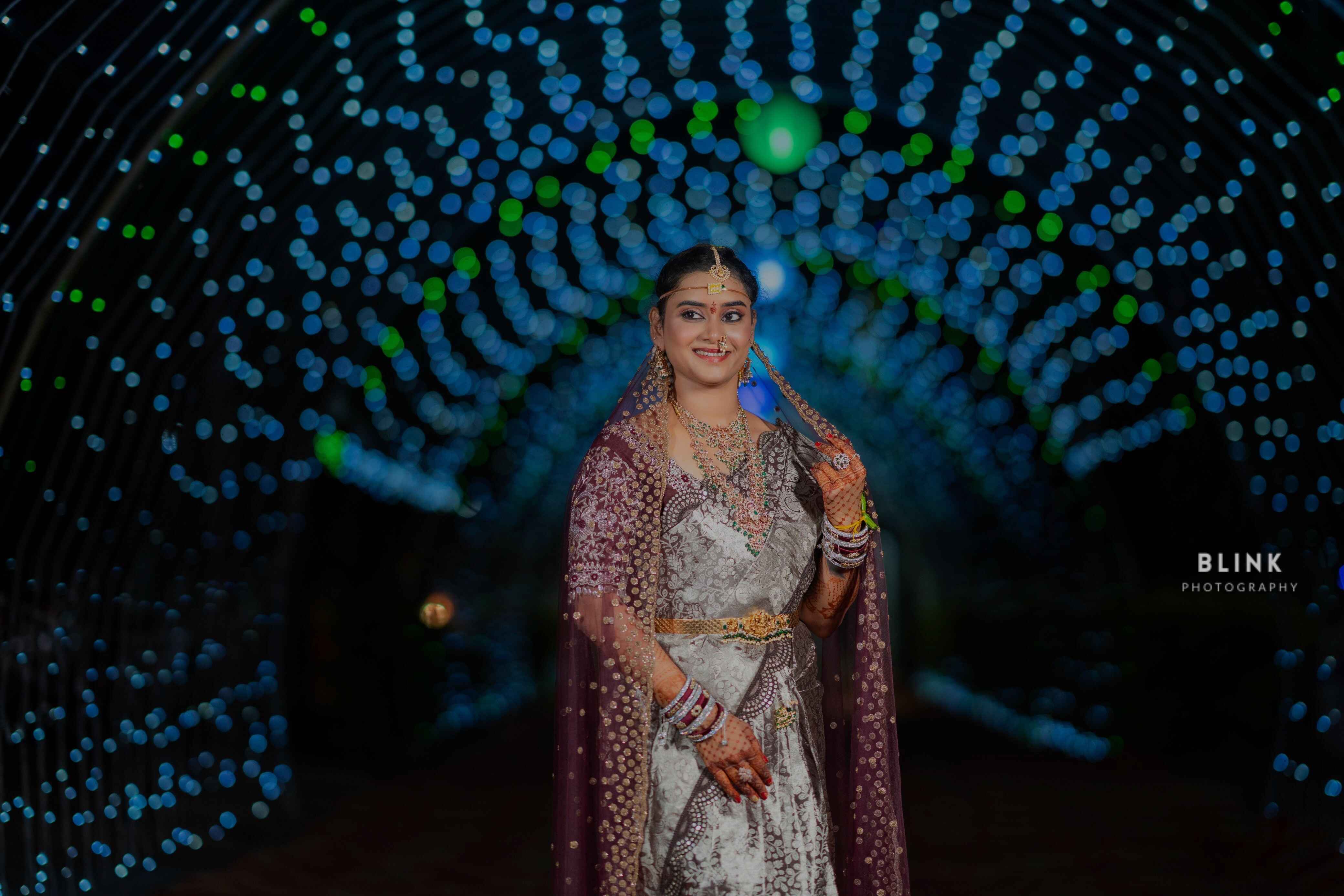 Bride standing in the street of wedding lights In Indian Wedding Saree and Jewellery