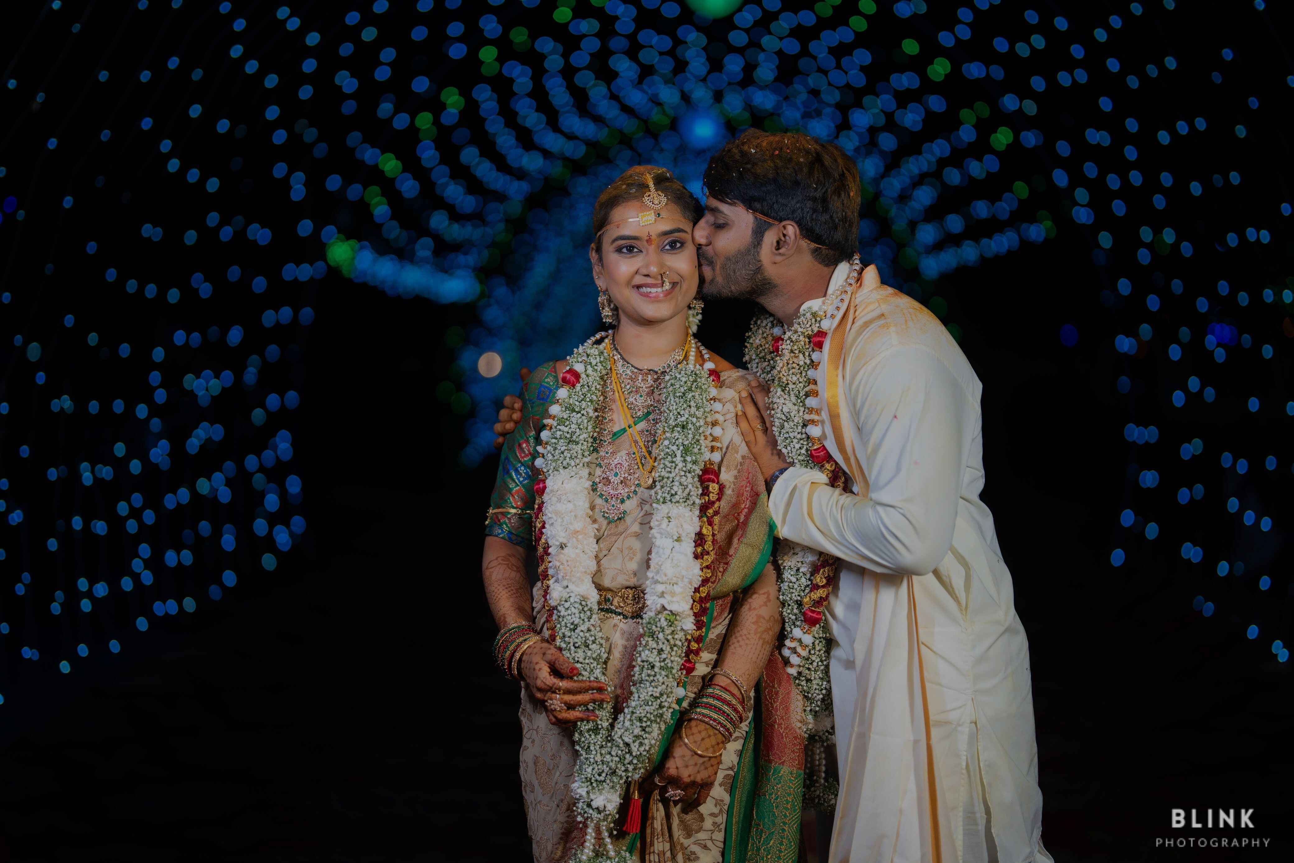 A picture of wedding couple kissing on wedding lights